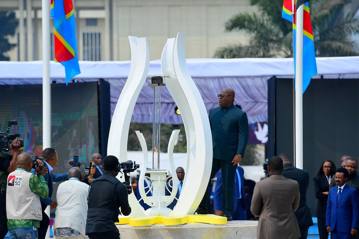 President Félix Tshisekedi stands beside the GENOCOST memorial flame, Congolese flags in the background